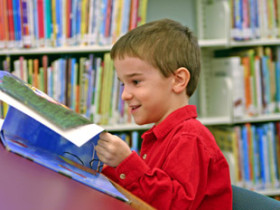 boy reading book at the library